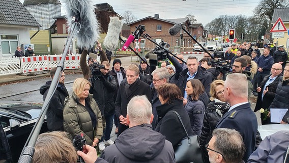 Bundesministerin Nancy Faeser (SPD) und Ministerpräsident Daniel Günther (CDU) stehen von Journalisten umgeben in Brokstedt. © NDR Foto: Carsten Salzwedel