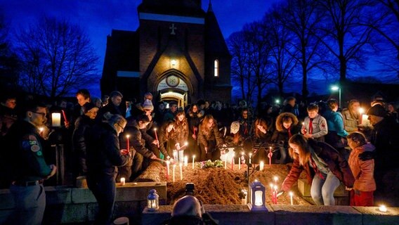 Teilnehmer der Andacht der Evangelisch-Lutherischen Kirchengemeinde Brokstedt für die Opfer des Messerangriffs stellen nach dem Gottesdienst Kerzen vor der Kirche auf. © dpa-Bildfunk Foto: Axel Heimken