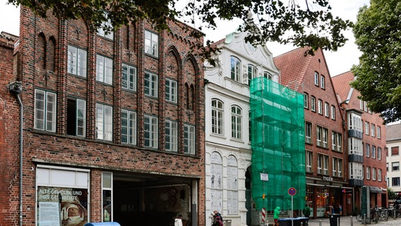 Links steht ein Backsteingebäude, rechts daneben ist ein weißes Gebäude zu sehen - das Buddenbrookhaus in Lübeck. © dpa Bildfunk Foto: Frank Molter