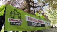 Menschen der Volksinitiative stehen mit einem Banner vor dem Kieler Landeshaus. © NDR 