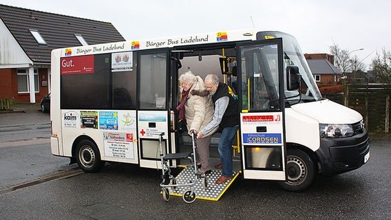 Der Busfahrer des Bürgerbusses hilft einer älteren Frau mit ihren Rollator aus dem Bus. © NDR Foto: Lena Haamann