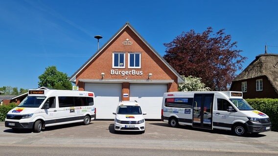 Drei Fahrzeuge stehen vor einem Gebäude, auf dem Gebäude steht "Bürgerbus" © BürgerBus Ladelund Foto: BürgerBus Ladelund
