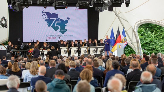 Geladene Gäste sitzen in einem großen Zelt auf dem Gelände von Schloss Gottorf anlässlich des Bürgerfestes zum 75. Landesgeburtstag von Schleswig-Holstein. © NDR Foto: Janis Röhlig
