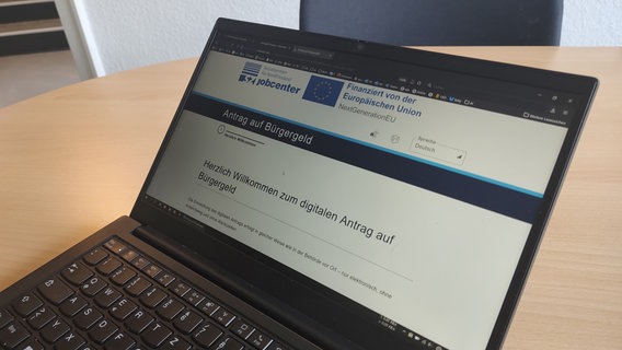 Auf einem Laptop ist die Internetseite des Jobcenters Nordfriesland zu sehen, auf der Bedürftige Bürgergeld beantragen können. © NDR Foto: Peer-Axel Kroeske