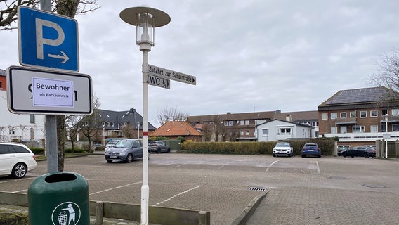 Ein Blatt Papier mit dem Schriftzug "Bewohner mit Parkausweis" klebt auf einem Zusatzschild unter einem Parkplatzschild in Büsum. © NDR Foto: Jonas Salto