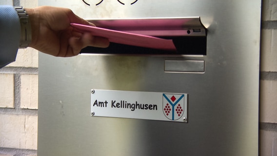 Ein Wähler wirft einen Umschlag in den Briefkasten des Amts Kellinghusen. © NDR 