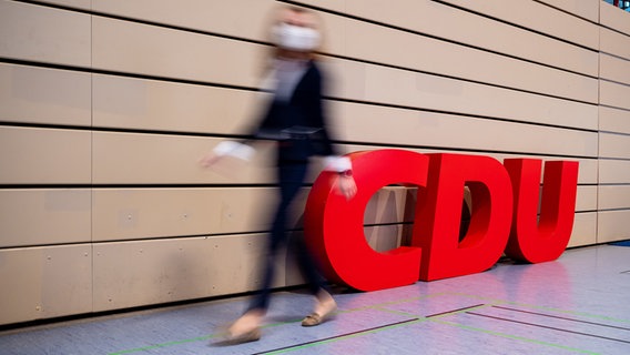 Eine Frau geht am Logo der CDU vorbei. © picture alliance/dpa Foto: Moritz Frankenberg