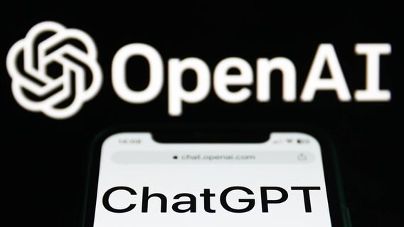 Auf einem Handy ist der Schriftzug ChatGPT zu lesen, dadrüber OpenAI. © IMAGO / NurPhoto 