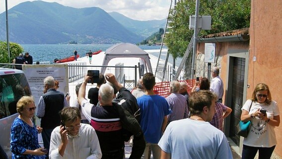Mehrere Menschen stehen am Iseosee in Italien. © NDR Foto: Hauke von Hallern / Julian Marxen