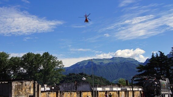 Ein Hubschrauber fliegt über einen Fabrikhalle in Italien. © NDR Foto: Hauke von Hallern / Julian Marxen