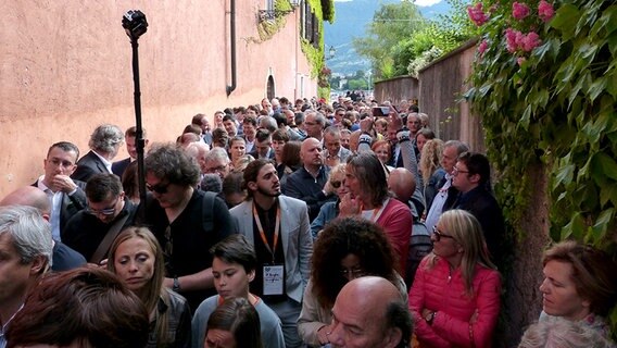 Eine Gasse des Ortes Sulzano in Italien ist am Eröffnungstag der "Floating Piers" von Christo menschengefüllt. © NDR Foto: Julian Marxen und Hauke von Hallern