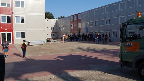 Schülerinnen und Schüler stehen auf dem Schulhof des neuen Container-Campus Schülerinnen und Schüler stehen auf dem Schulhof des neuen Container-Campus © NDR Foto: Robert Tschuschke