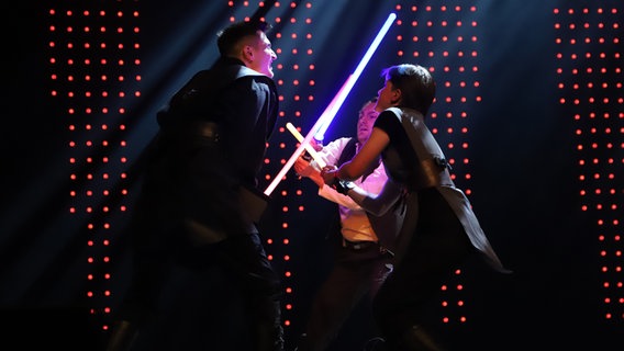 Verkleidete Star Wars-Fans führen einen Kampf mit Lichtschwertern vor. © NDR Foto: Martina Heller