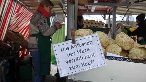 Ein Wochenmarkt-Stand, an dem ein Schild befestigt ist, der darauf hinweist, dass das Anfassen der Ware zum Kauf verplichtet. © NDR Foto: Lornz Lorentzen