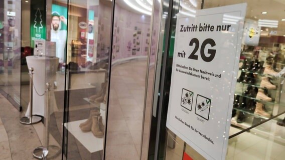 An einem Geschäft hängt ein Zettel mit der Aufschrift: "Zutritt bitte nur mit 2G" © IMAGO / Seeliger Foto: Seeliger