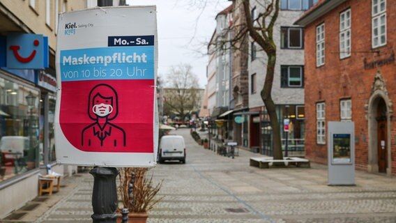 Ein Hinweisschild zur Maskenpflicht hängt in einer Innenstadt. © NDR Foto: Christoph Klipp