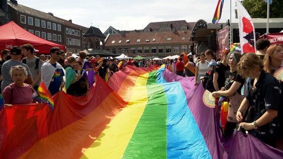 Beim Christopher-Street-Day in Lübeck wird eine große Regenbogenfahne entfaltet. © NDR Foto: NDR Screenshots