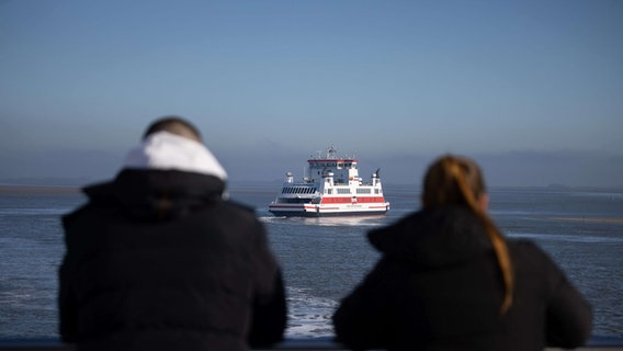 Passagiere stehen an Deck der Fähre "Schleswig-Holstein" der Wyker Dampfschiffs-Reederei (WDR) auf dem Weg von Dagebüll nach Föhr und schauen auf die Fähre "Uthlande" auf dem Weg nach Dagebüll. © picture alliance/dpa | Christian Charisius Foto: Christian Charisius