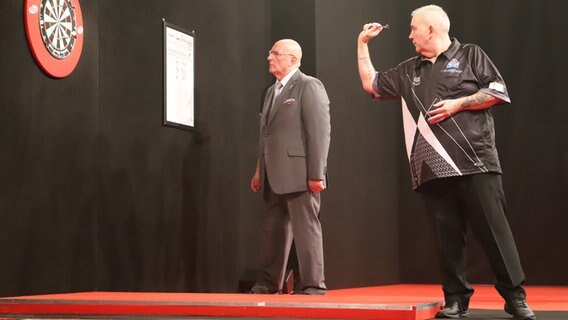 Ein Mann wirft einen Wurfpfeil in die Dartscheibe beim Darts Turnier in der Kieler Ostseehalle. © NDR Foto: Marina Heller