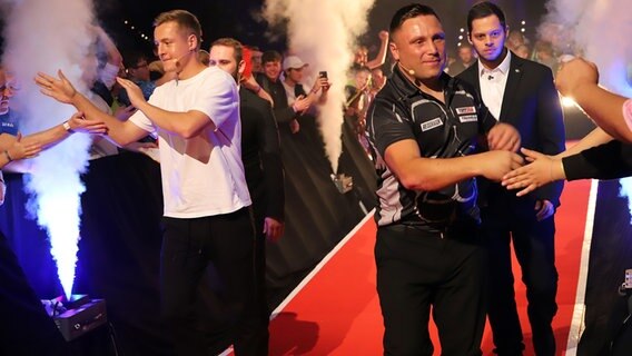 Fußballer Toni Kroos und sein Teampartner Gerwyn Price klatschen ihre Fans beim Einlaufen zum Darts Turnier in der Kieler Ostseehalle ab. © NDR Foto: Marina Heller