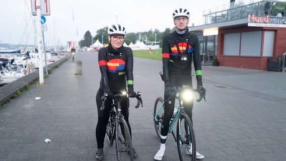 Robin und Bente stehen mit ihren Fahrrädern an der Kiellinie. © NDR Foto: Lisa Pandelaki