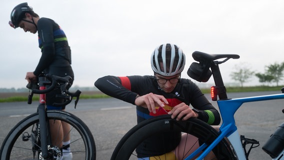 Ein Fahrradfahrer flickt seinen platten Reifen © NDR Foto: Lisa Pandelaki