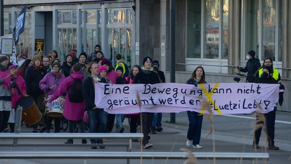 Menschen demonstrieren in Kiel gegen den Abbau von Kohle mit einem Banner: Eine Bewegung kann nicht geräumt werden #Luetzi lebt. © NDR 