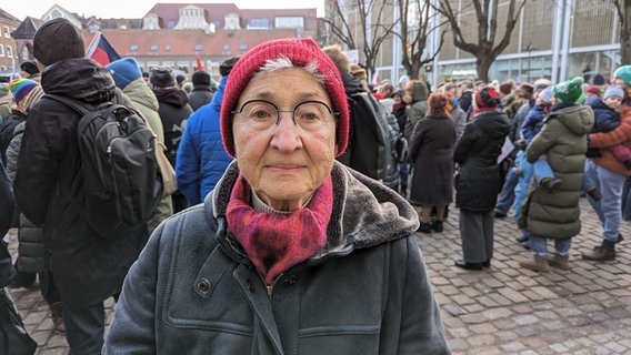 Eine ältere Frau blickt in die Kamera bei einer Demonstration in Lübeck auf dem Rathausplatz gegen Rechtsextremismus. © NDR Foto: Phillip Kamke