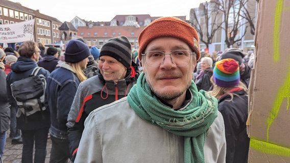 Ein Mann blickt in die Kamera bei einer Demonstration in Lübeck auf dem Rathausplatz gegen Rechtsextremismus. © NDR Foto: Phillip Kamke