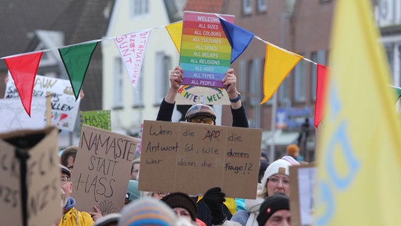 Während einer Demonstration gegen rechts werden mehrere Plakate in die Luft gehalten. © NDR Foto: Marian Schäfer