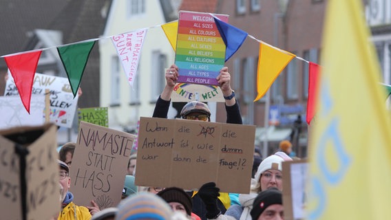 Während einer Demonstration gegen rechts werden mehrere Plakate in die Luft gehalten. © NDR Foto: Marian Schäfer