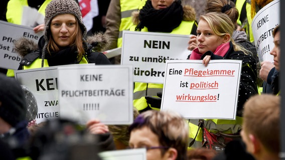 Demonstranten proestieren mit erhobenen Schildern. © dpa-Bildfunk Foto: Carsten Rehder