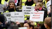 Demonstranten proestieren mit erhobenen Schildern. © dpa-Bildfunk Foto: Carsten Rehder