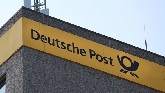 Das Logo der Deutschen Post ist samt Schriftzug auf einem gelben Hintergrund auf einem Hochhaus am Bahnhof Neumünster zu sehen. © NDR Foto: Pavel Stoyan