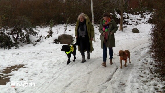 Zwei Frauen gehen mit Hunden im Schnee spazieren. © NDR 