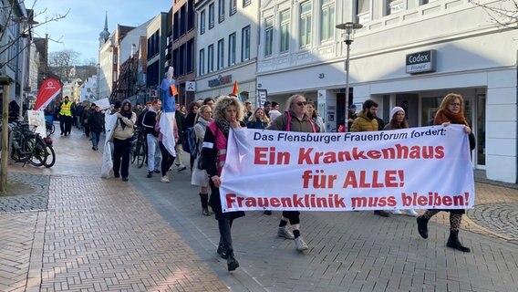 Bei einer Demonstration in Flensburg steht auf einem Banner: "Ein Krankenhaus für alle! Frauenklinik muss bleiben!" © NDR Foto: Jörn Zahlmann