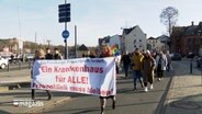 Bei einer Demonstration in Flensburg steht auf einem Banner: "Ein Krankenhaus für alle! Frauenklinik muss bleiben!" © NDR 