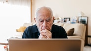 Ein Senior sitzt verzweifelt vor einem Laptop. © IMAGO / Westend61 