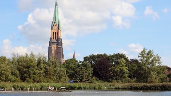 Eine Außenaufnahme vom Schleswiger Dom. Im Vordergrund die Schlei nahe der Königswiesen. © Nordkirche Foto: Antje Wendt