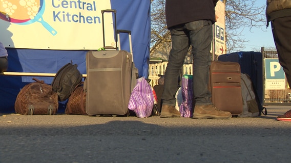 Ukrainische Flüchtlinge warten mit ihrem Gepäck auf die Weiterfahrt.  