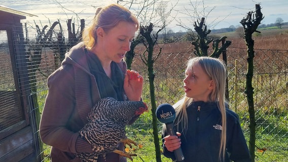 Mandy Schmidt und Mila aus Kronshagen führen ein Interview bei den Hühnern "Mandys Mädels" © Philipp und Tabea Grave Foto: Philipp und Tabea Grave