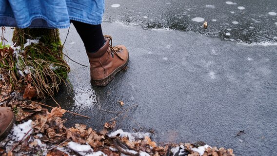 Eine Person betritt eine zugefrorene Eisfläche. © Picture Alliance Foto: Annette Riedl