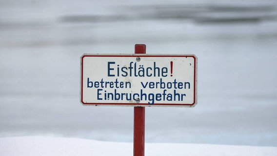 Vor einer EIsfläche steht ein Schild it der Aufschrift "Eisfläche! betreten verboten Einbruchgefahr" © imago images / Ralph Peters Foto: Ralph Peters