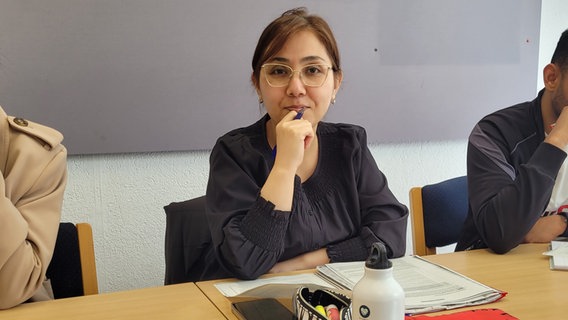 Nadja Elham mit Schreibutensilien an einem Tisch. © NDR Foto: Frank Goldenstein