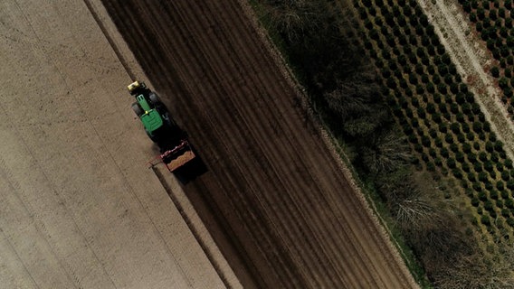 Vogelperspektive: Ein Traktor fährt auf einem Kartoffelacker © NDR Foto: NDR
