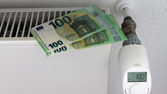 Zwei Hundert-Euro-Scheine liegen auf einem Heizkörper. Der Thermostat zeugt 18 Grad Celsius an. © epd / Imago Images Foto: epd