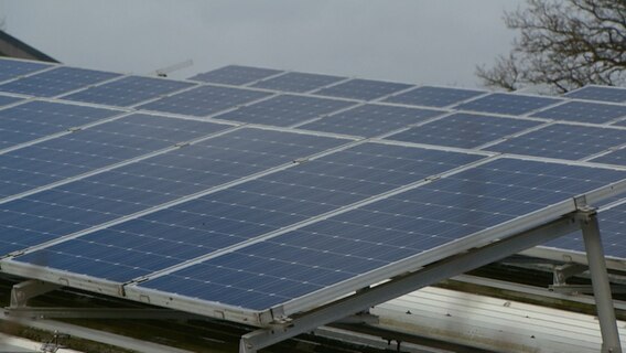 Eine Photovoltaik-Anlage auf einer grünen Lagerhalle. © NDR 