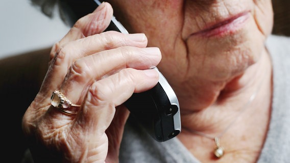 Eine Seniorin hält sich ein Telefon an ihr Ohr. © dpa Foto: Karl-Josef Hildenbrand/dpa