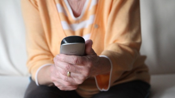 Eine ältere Dame hält ein Telefon in der Hand. © picture alliance / Eibner-Pressefoto | Fleig Foto: picture alliance / Eibner-Pressefoto | Fleig