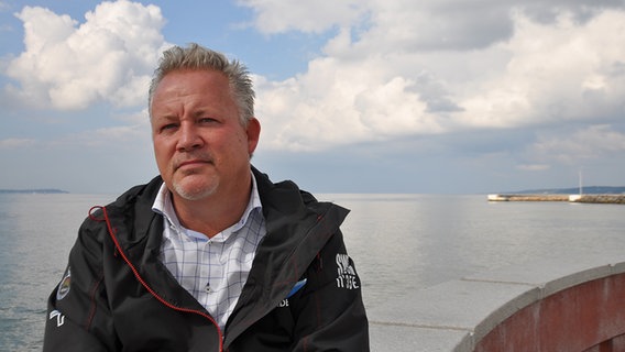 Kent Härstedt sitzt am Meer und blickt in die Kamera. © NDR Foto: Christian Wolf